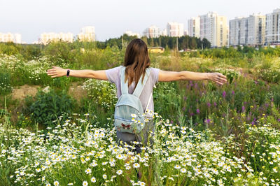 Full length of young woman with flowers in garden