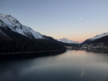 Scenic view of lake and snowcapped mountains against clear sky