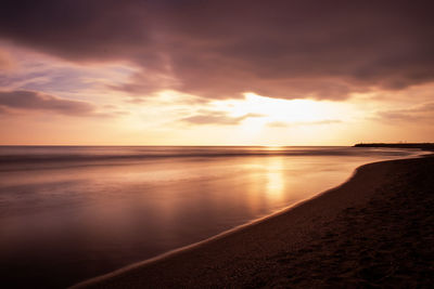 Scenic view of sea against sunset sky