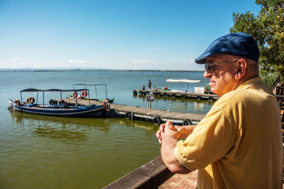 Side view of man on boat in sea against sky