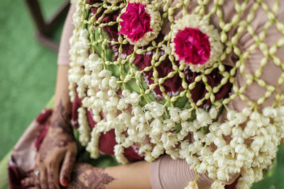 Close-up of woman holding bouquet of flowering plant