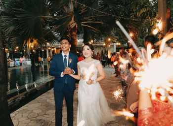 Rear view of bride and groom standing at night