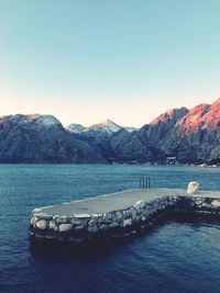 Scenic view of sea and mountains against clear sky