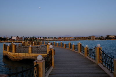 Pier on river against buildings in city