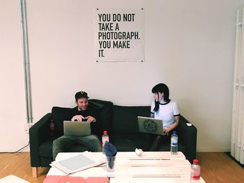 Man and woman sitting on sofa with laptop at office