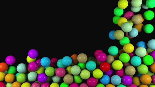 Close-up of multi colored balloons against black background