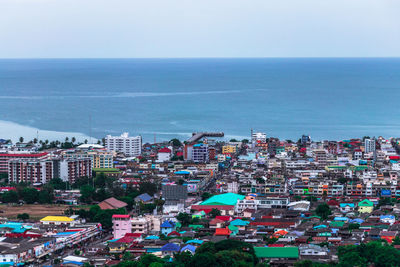 High angle view of buildings by sea against sky