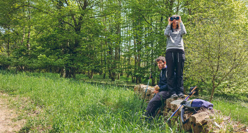 Man sitting on field in forest