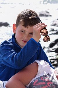 Portrait of boy sitting on land