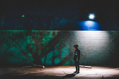 Man standing on road at night