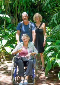 Portrait of senior woman with couple sitting on wheelchair