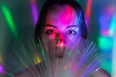 Close-up portrait of woman amidst illuminated lights