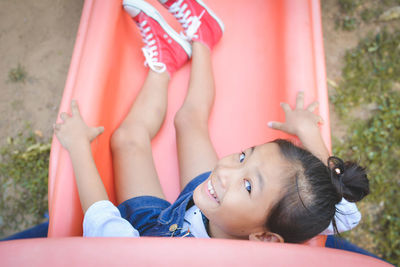 Directly above portrait of girl playing on slide