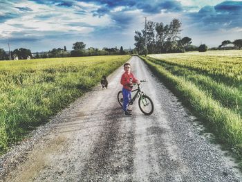 Man riding motorcycle on road amidst field