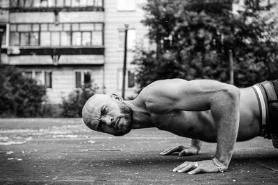 Side view of shirtless man with arms outstretched