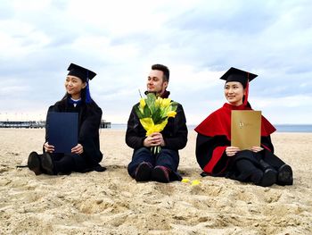 Two people sitting on beach