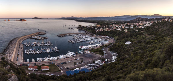 Scenic view of harbor and residential district by sea during sunset