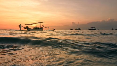 Silhouette ship in sea against sky during sunset