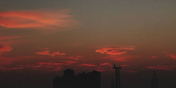 Silhouette city against sky during sunset
