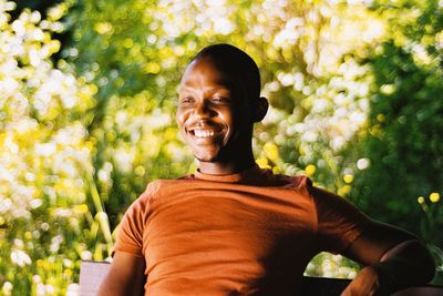 Portrait of smiling man from ghana against plants