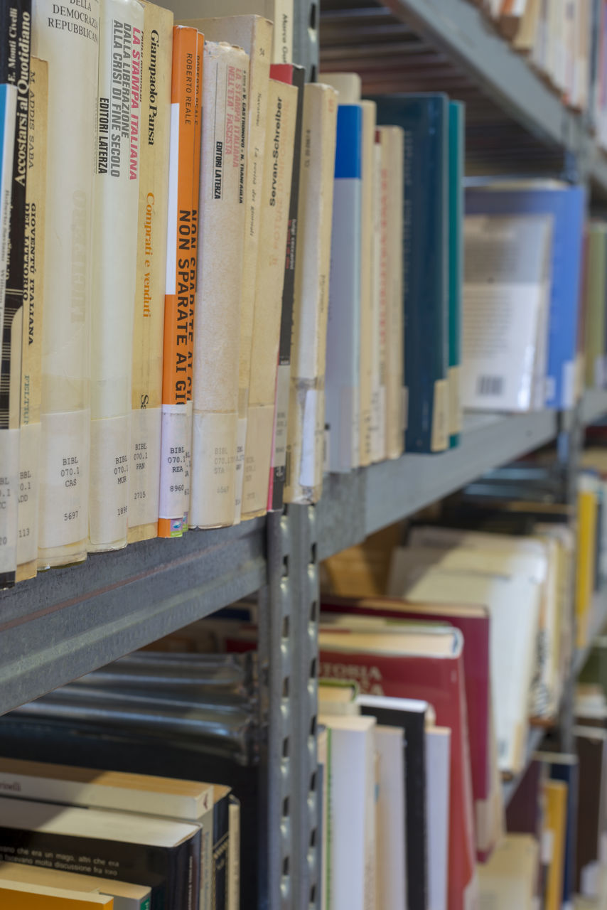 CLOSE-UP OF BOOKS ON SHELF IN LIBRARY