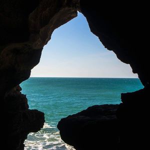 Scenic view of sea seen through cave