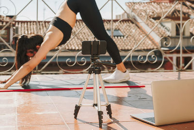 Young sporty fit woman coach doing online lessons through video call on her mobile phone 