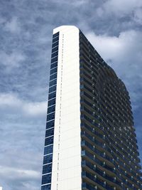 Low angle view of modern building against cloudy sky