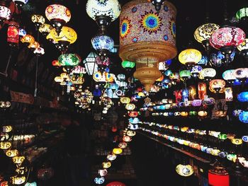 Illuminated lanterns hanging at market stall