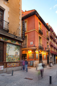 People walking on street amidst buildings in city