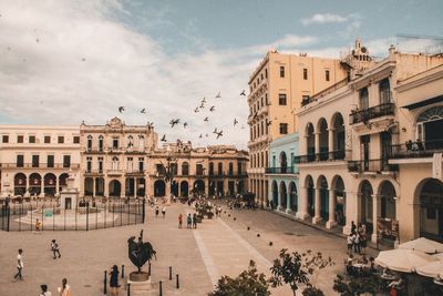 Buildings in town against cloudy sky