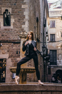 Portrait of smiling young woman jumping in city