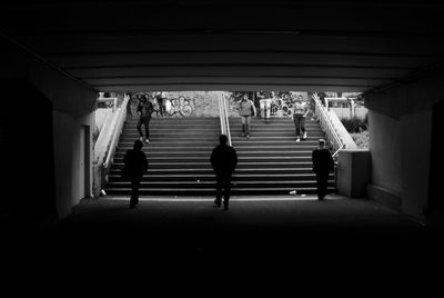 Rear view of people walking on staircase