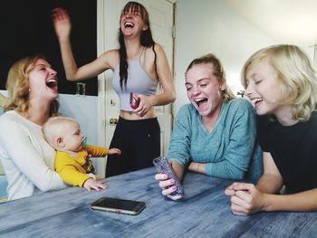 Happy family using mobile phone at home