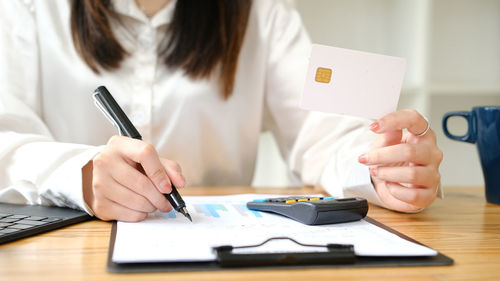 Midsection of woman working at table