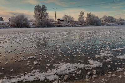 Scenic view of snow covered land against sky