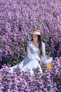 Midsection of woman with purple flowers