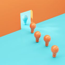 Close-up of light bulb against colored background