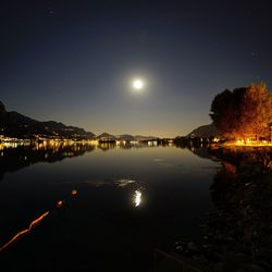 Scenic view of lake against clear sky at night