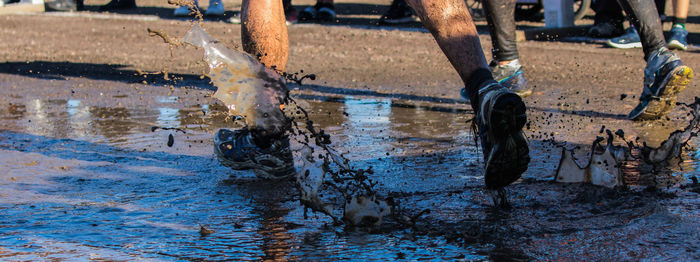 Low section of people running in puddle