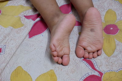 Low section of baby feet on bed