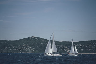 Sailboat sailing on sea against sky