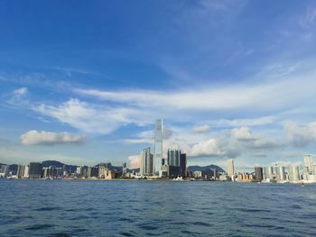 Sea by buildings against sky in city