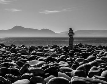 Scenic view of rocks at beach against sky