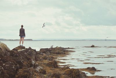 Woman on beach against sky