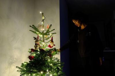 Woman looking at illuminated christmas tree