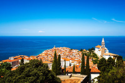 Buildings by sea against sky