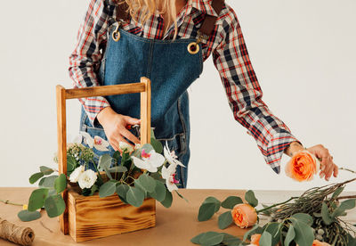 Woman holding flower pot on table