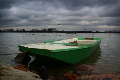 Boats moored at sea shore against sky