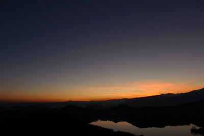 Scenic view of silhouette mountains against sky at sunset